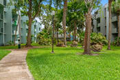 Thumbnail 7 of 30 - a path through the grass in front of an apartment building