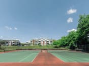 Thumbnail 21 of 26 - a tennis court with apartments in the background