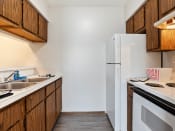 Thumbnail 2 of 16 - apartment kitchen with white appliances and wooden cabinets