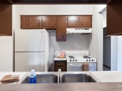 Thumbnail 3 of 16 - a kitchen with white appliances and wooden cabinets and a double bowl sink