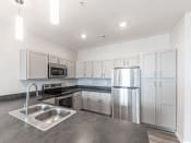 Thumbnail 10 of 22 - a kitchen with white cabinets and stainless steel appliances