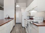 Thumbnail 1 of 15 - apartment kitchen with white appliances and wooden counter tops and white cabinets