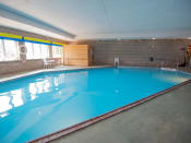 Thumbnail 18 of 32 - a large indoor swimming pool with brick walls and a blue ceiling