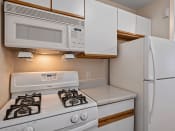 Thumbnail 11 of 25 - a kitchen with a stove refrigerator and microwave