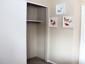 Thumbnail 14 of 31 - a closet with a sliding door and three pictures of butterflies on the wall