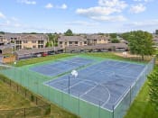 Thumbnail 26 of 29 - a tennis court with apartments in the background