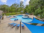 Thumbnail 24 of 29 - a resort style pool with blue umbrellas and chairs