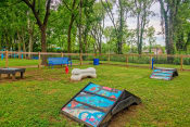 Thumbnail 18 of 25 - Apartments Nashville TN - The Canvas - Gated Bark Park with Obstacle Equipment, Bench Seating, and Lush Grass