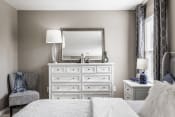 Thumbnail 11 of 16 - a bedroom with a large white dresser with a mirror on top of it