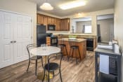 Thumbnail 20 of 34 - Arbors at Turnberry Apartments Pickerington Ohio Pet Friendly Updated Modern Kitchen wood style flooring, stone style countertops, kitchen island, dining area, and pantry