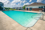 Thumbnail 34 of 34 - Pet Friendly Apartments in Pickerington, OH - Arbors at Turnberry - Pool with Lounge Chairs, Concrete Deck, and Building in the Background.