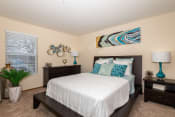 Thumbnail 8 of 23 - One BR Apartments in Hilliard, OH - Residences at Breckenridge - Bedroom with Carpet Flooring, Bed, Dresser, Nightstands, Lamps, and a Window.