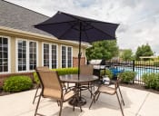 Thumbnail 15 of 23 - 1 BR Apartments in Hilliard, OH - Residences at Breckenridge - BBq Area with Grill, Table, Chairs, and Umbrella Near the Pool.