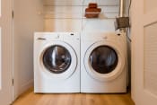 Thumbnail 9 of 19 - a washer and dryer sit side by side in a laundry room