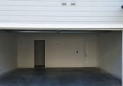 Thumbnail 9 of 13 - an empty garage in a building with a door