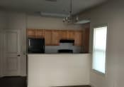 Thumbnail 2 of 13 - an empty kitchen with wooden cabinets and a white counter top