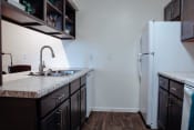 Thumbnail 15 of 26 - a kitchen with dark cabinets and a white refrigerator