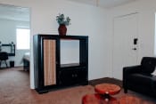 Thumbnail 21 of 26 - a living room with a black chair and a black china cabinet with a plant on top