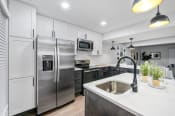 Thumbnail 29 of 42 - a kitchen with white cabinets and stainless steel appliances