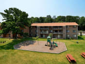 Thumbnail 6 of 18 - Far away view of apartment complex with playground at Gainsborough Court Apartments, Fairfax, VA