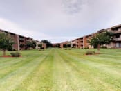 Thumbnail 17 of 18 - Lawn area with exterior view of apartment complex at Gainsborough Court Apartments, Fairfax