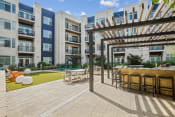 Thumbnail 38 of 50 - an outdoor patio with tables and chairs at the bradley braddock road station apartments