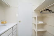 Thumbnail 7 of 15 - a walk in closet with white cabinets and a white door