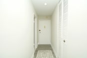 Thumbnail 8 of 15 - a hallway with a white door and white walls