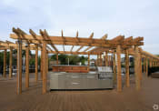 Thumbnail 12 of 22 - an outdoor kitchen with a wooden pergola