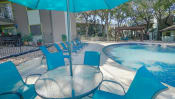 Thumbnail 16 of 25 - a swimming pool with a table and chairs next to it at Elevate at Huebner Grove, San Antonio