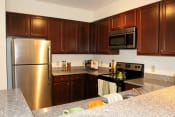 Thumbnail 18 of 36 - a kitchen with stainless steel appliances and granite counter tops at Chester Village Green Apartments, Chester, VA