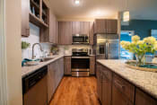 Thumbnail 21 of 30 - a kitchen with wooden cabinets and stainless steel appliances