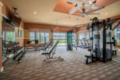 Thumbnail 3 of 30 - a gym with weights and other equipment in a room with windows