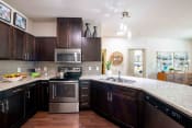Thumbnail 19 of 30 - a kitchen with wooden cabinets and stainless steel appliances