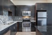 Thumbnail 48 of 53 - a kitchen with stainless steel appliances and black cabinets