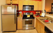 Thumbnail 21 of 36 - a kitchen with stainless steel appliances and a refrigerator at Chester Village Green Apartments, Chester
