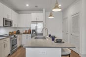 Thumbnail 3 of 41 - a kitchen with white cabinets and stainless steel appliances