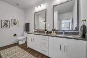 Thumbnail 10 of 41 - a bathroom with white cabinets and a large mirror