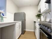 Thumbnail 20 of 23 - a kitchen with white cabinets and a stainless steel refrigerator
