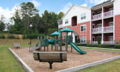Thumbnail 24 of 47 - Playground with bench at the Haven at Reed Creek Apartments Martinez, GA