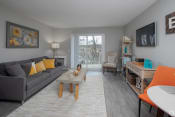 Thumbnail 9 of 18 - a living room with gray walls and a sliding glass door leading to a balcony
