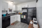 Thumbnail 8 of 18 - a kitchen with white cabinets and black appliances