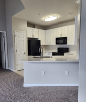 Thumbnail 5 of 25 - a kitchen with white cabinets and a counter top