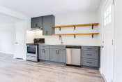 Thumbnail 12 of 34 - a kitchen with gray cabinets and white walls