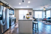 Thumbnail 3 of 33 - a kitchen and living room with stainless steel appliances and hardwood floors at Park 33, Goshen, 46526