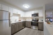 Thumbnail 4 of 8 - a kitchen with white cabinets and stainless steel appliances