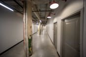 Thumbnail 7 of 23 - a view down a long corridor with white walls and grey doors
