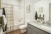 Thumbnail 10 of 42 - a bathroom with a white toilet next to a bathtub with a shower curtain