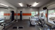 Thumbnail 7 of 17 - a gym with cardio equipment and windows