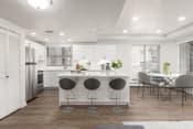 Thumbnail 5 of 34 - Kitchen with a kitchen island, hardwod flooring, white cabinetry, and stainless steel appliances